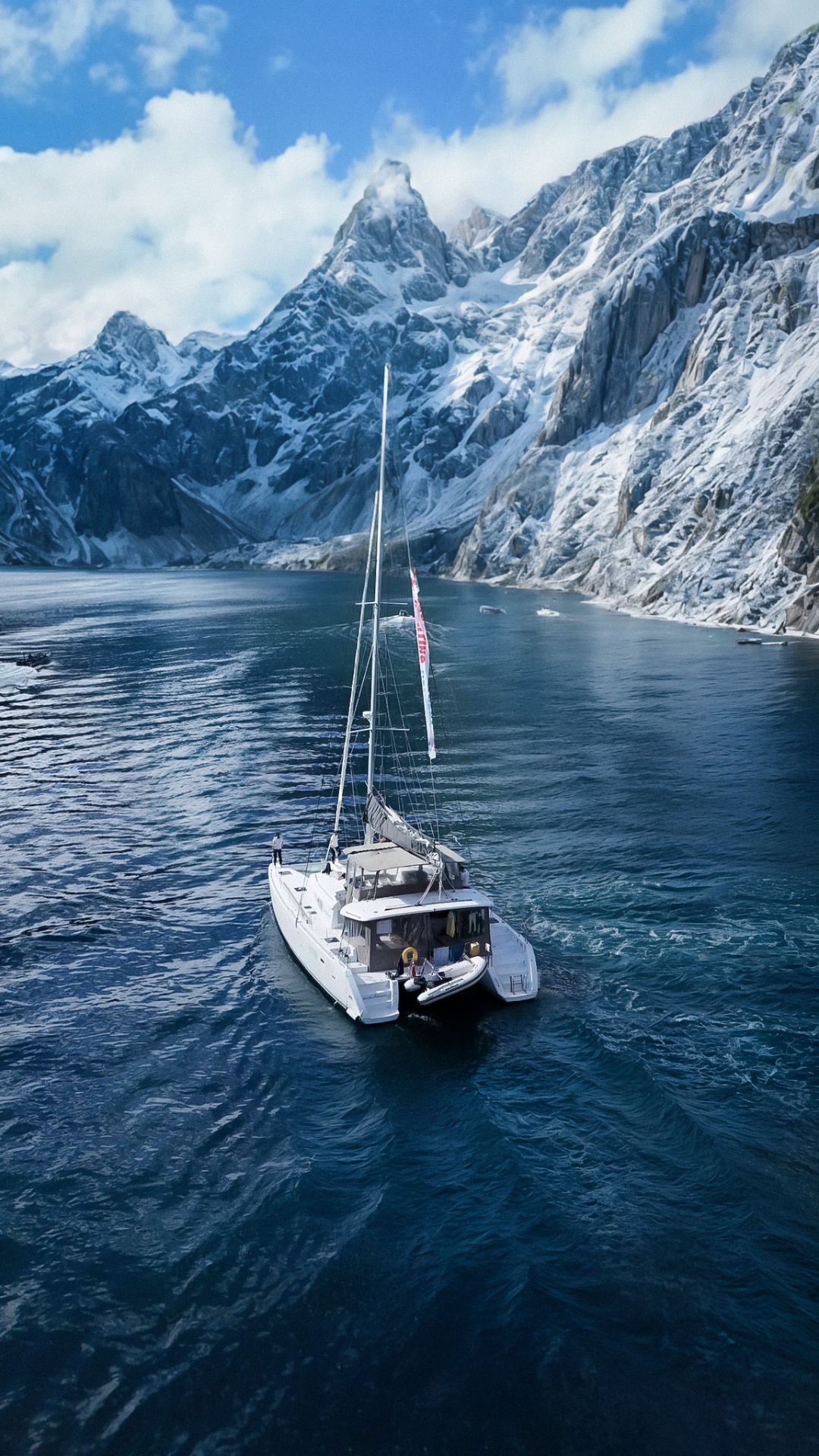 Catamaran beneath snow-capped peaks