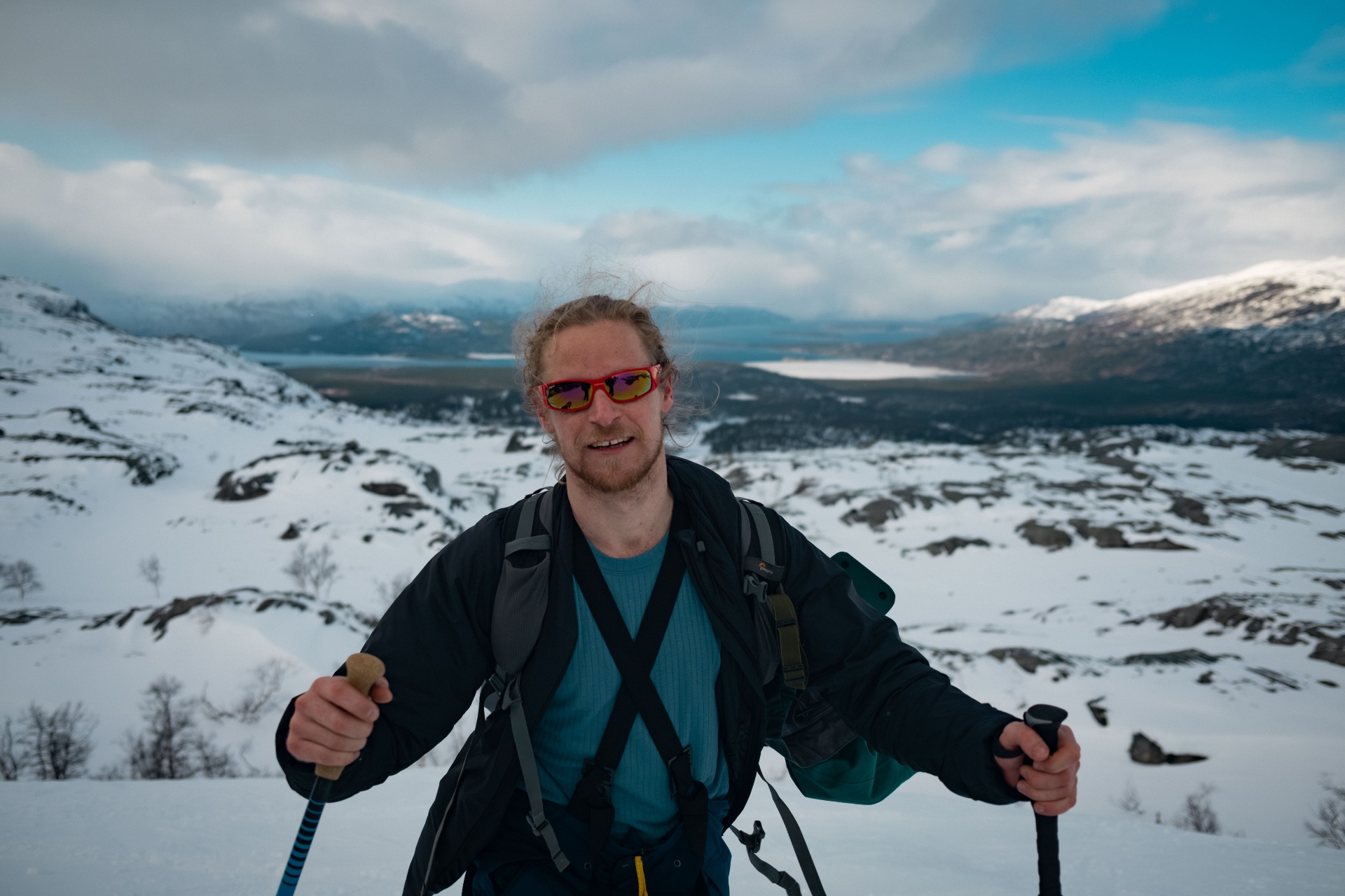 Ski-tourer on a snowy ridge above the fjord