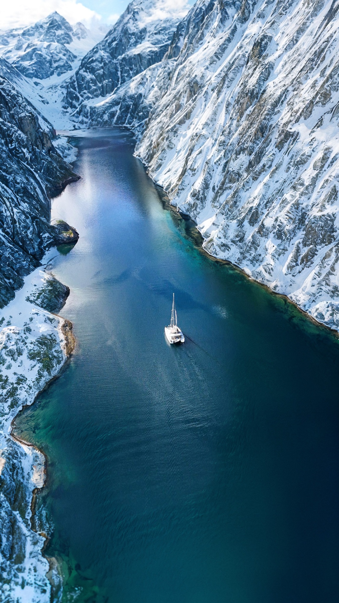 Aerial view of catamaran in a snowy fjord