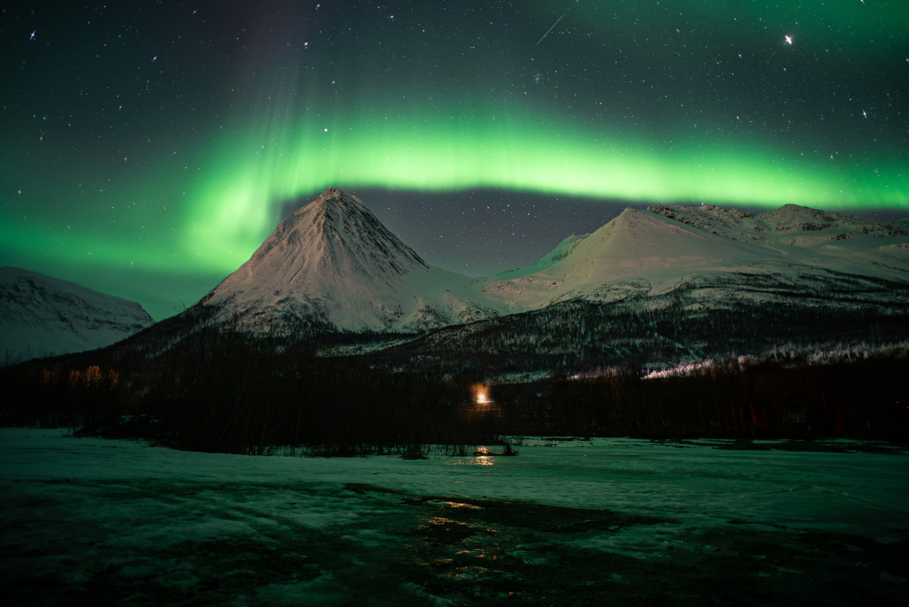 Aurora borealis over a snow-covered peak
